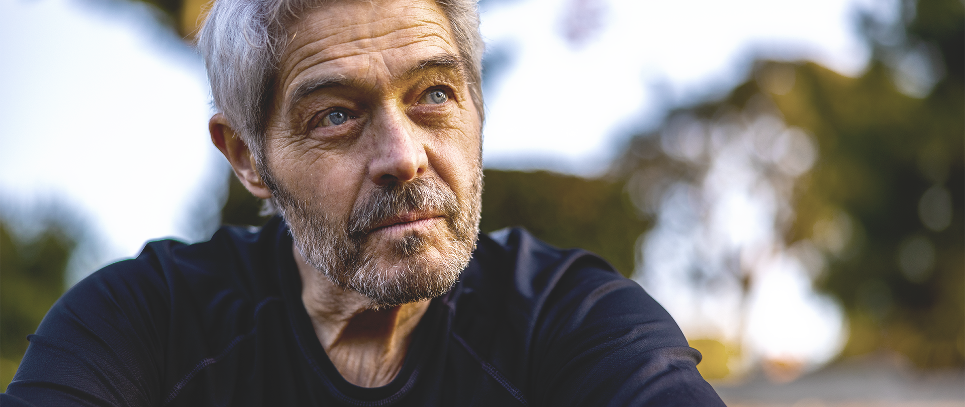 Ein fragend schauender Mann mittleren Alters denkt über Fragen zum Thema Tiefe Hirnstimulation (THS) nach